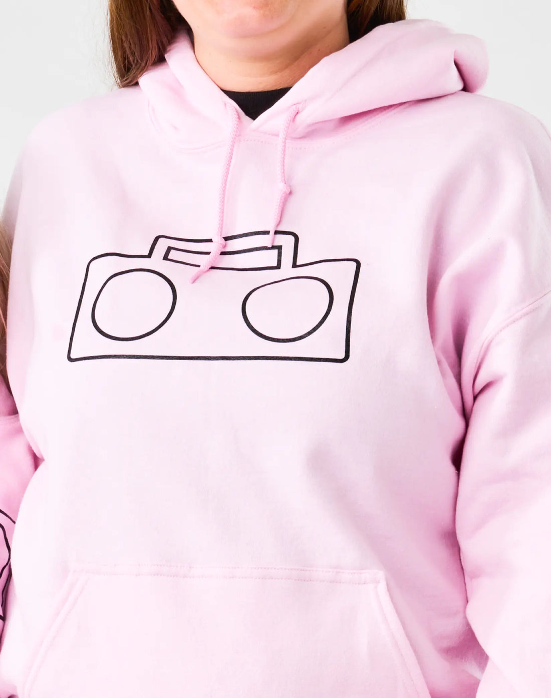 Close-up of StereoType Kids pink adult Boombox Logo Hoodie showing black boombox outline graphic on chest