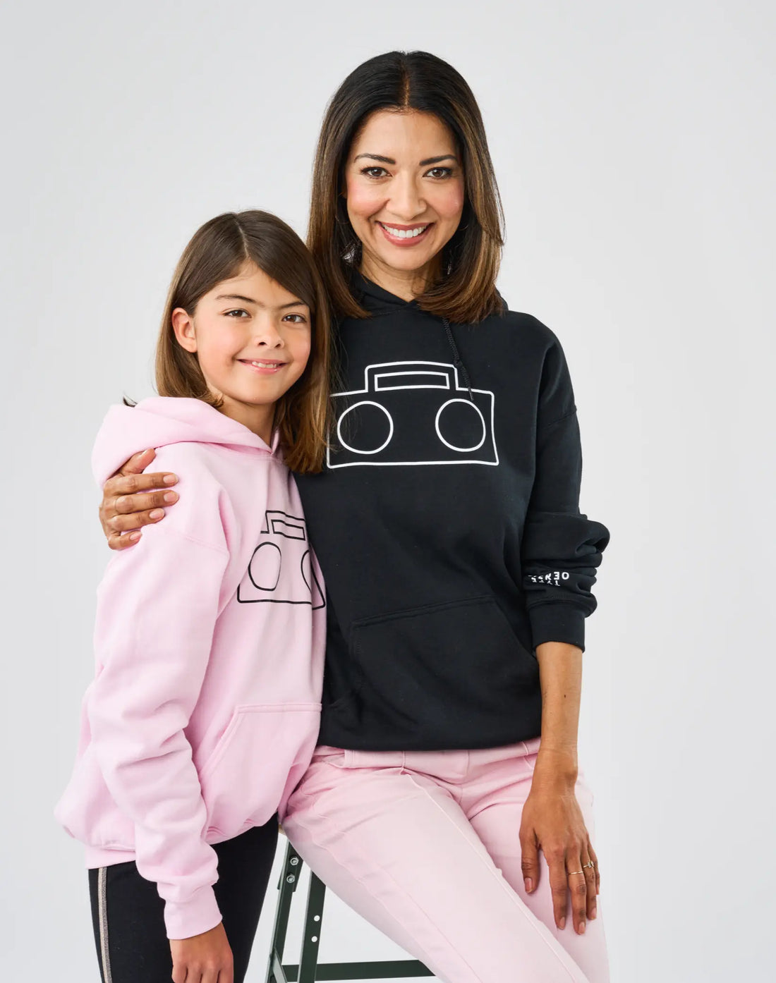 StereoType Kids founder Elizabeth Brunner in black Boombox Logo Hoodie and co-founder Chloe Brunner in pink Boombox Logo Hoodie, Mini-Me styling 