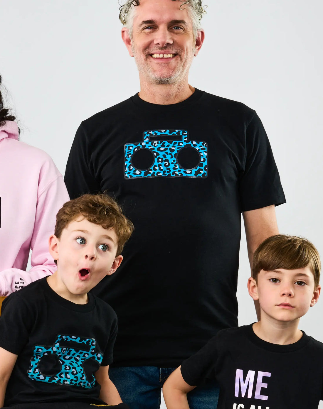 Adult and two children wearing StereoType Kids Cheetah Boombox unisex black graphic tees with teal blue cheetah print boombox logo, gender-inclusive Mini-Me fashion designed in San Francisco