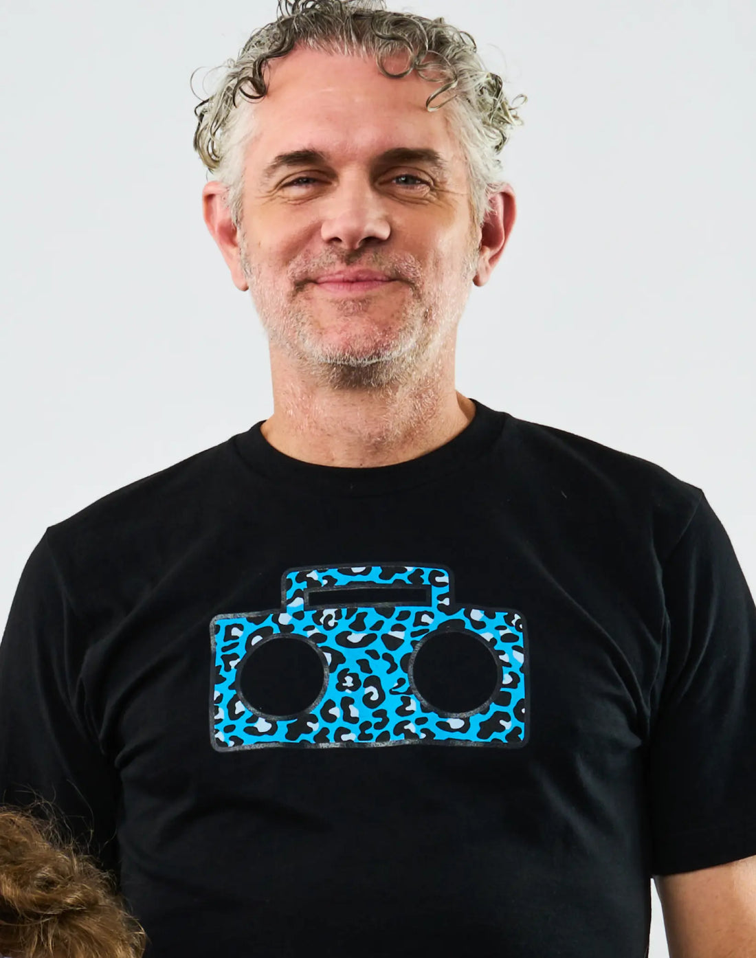Adult wearing StereoType Kids Cheetah Boombox unisex adult black graphic tee featuring teal blue cheetah print boombox logo, gender-inclusive blended fashion