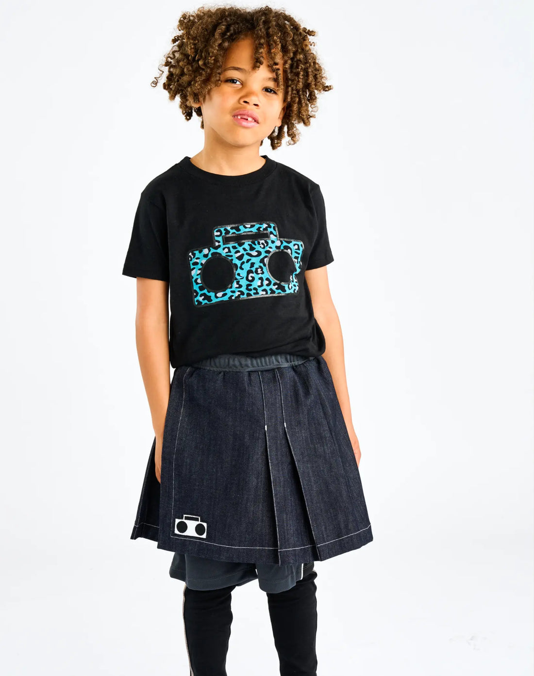 Child wearing StereoType Kids Cheetah Boombox unisex kids black graphic tee with Athletic Skort and Sparkle Leggings, gender-inclusive kids fashion designed in San Francisco