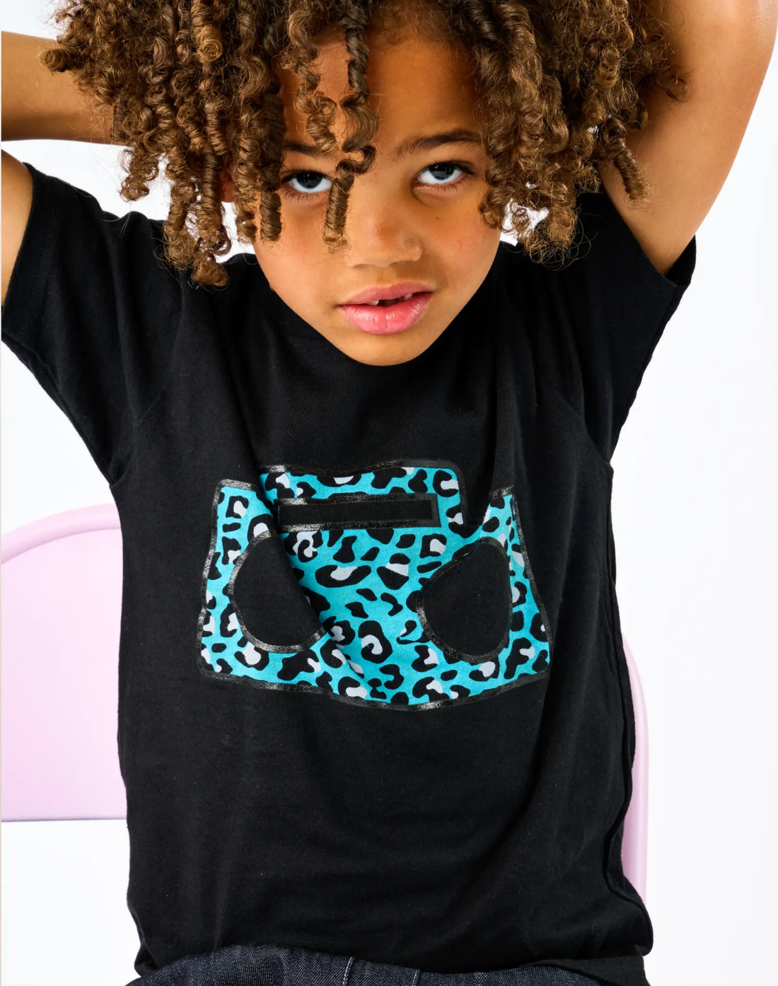 Child wearing StereoType Kids Cheetah Boombox unisex kids black graphic tee featuring teal blue cheetah print boombox logo, gender-inclusive kids fashion