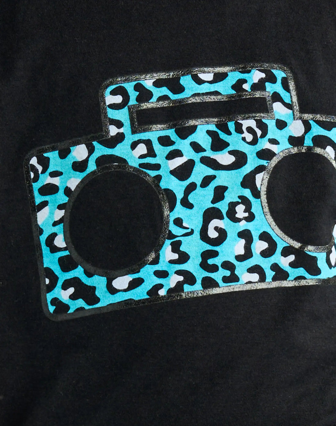 Close-up detail of StereoType Kids Cheetah Boombox tee showing teal blue cheetah print boombox graphic on black 100% cotton