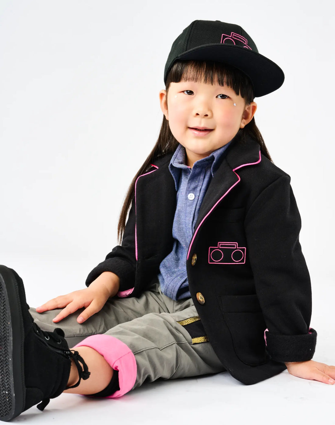 Child wearing StereoType Kids Hot Pink Boombox Blazer in black recycled knit fleece with Boombox Baseball Cap, Chambray Button-Down Zip Shirt and Active Pant, gender-inclusive unisex kids blazer