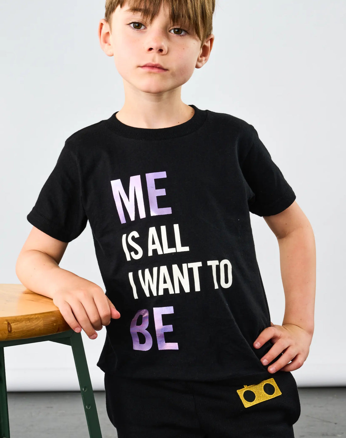Child wearing StereoType Kids Me Is All I Want To Be unisex kids black graphic tee with holographic lettering and Boombox Knit Sweatpants with gold Boombox and Dandelion embroidered patches