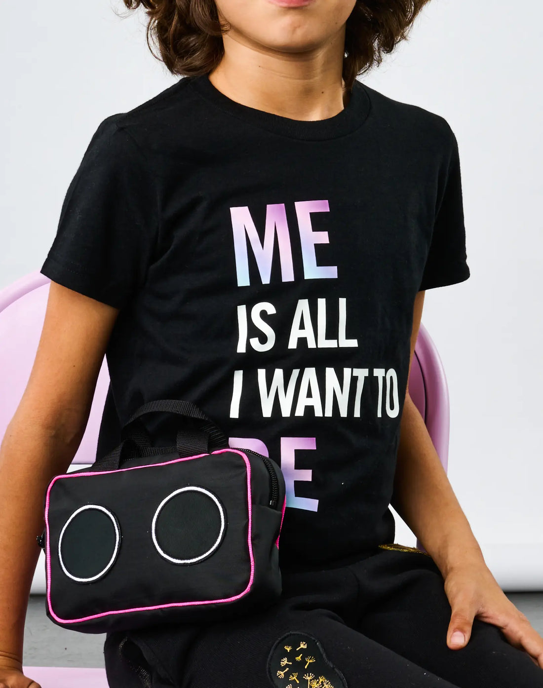 Child wearing StereoType Kids Me Is All I Want To Be unisex kids black graphic tee with gradient lettering, holding Boombox Treasure Bag
