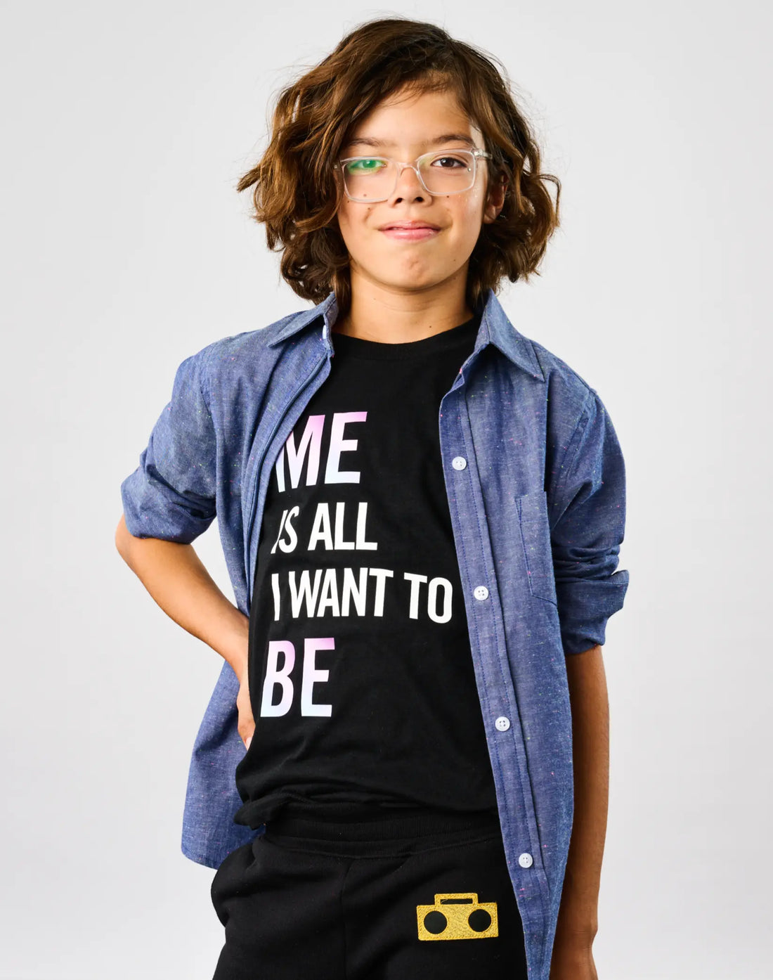 Child wearing StereoType Kids Me Is All I Want To Be unisex kids black graphic tee layered under Chambray Button-Down Zip Shirt with Boombox Knit Sweatpants