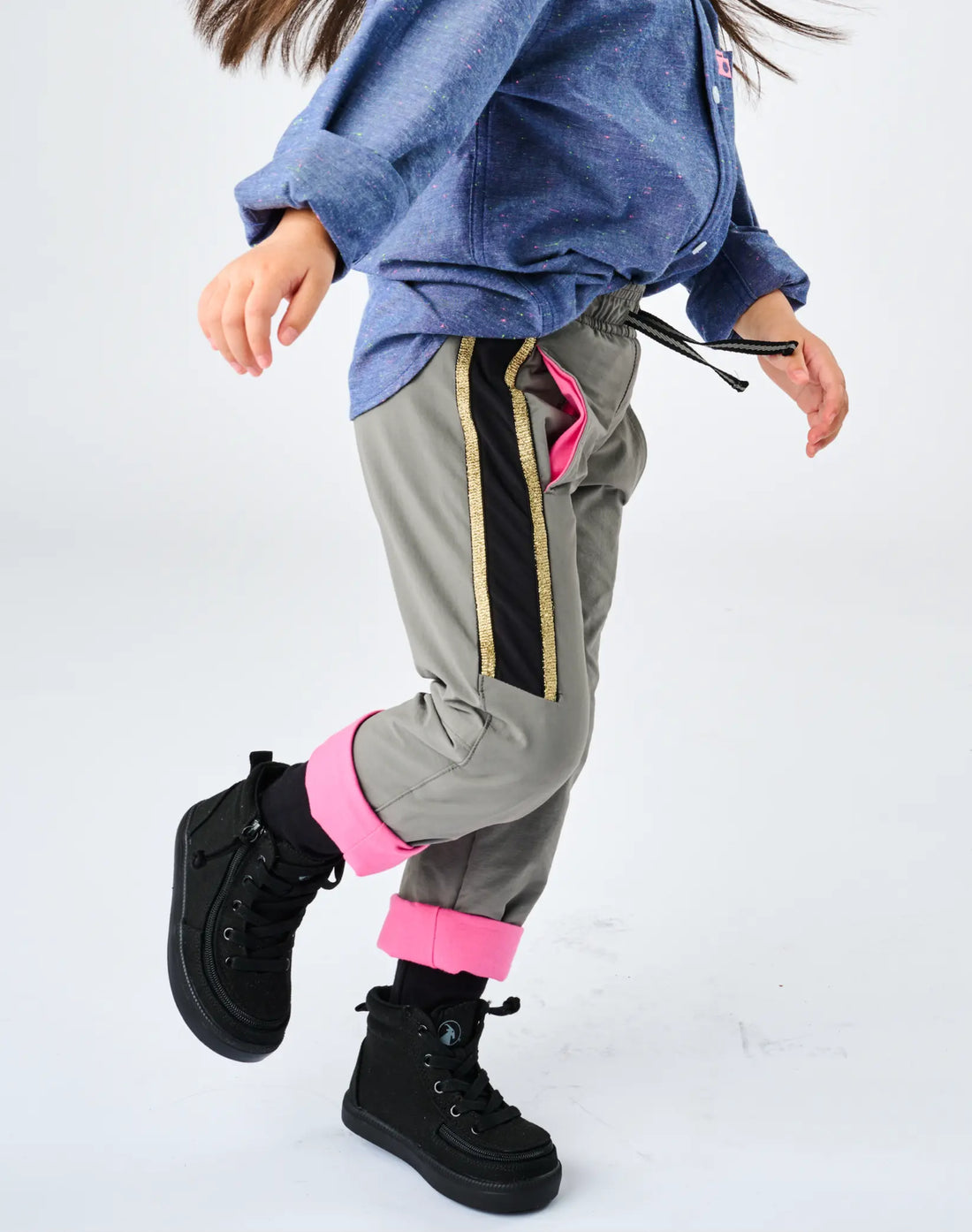 Stereotype Kids Active Pant in motion showing pink-lined pocket opening, gold sparkle stripe and drawstring waist