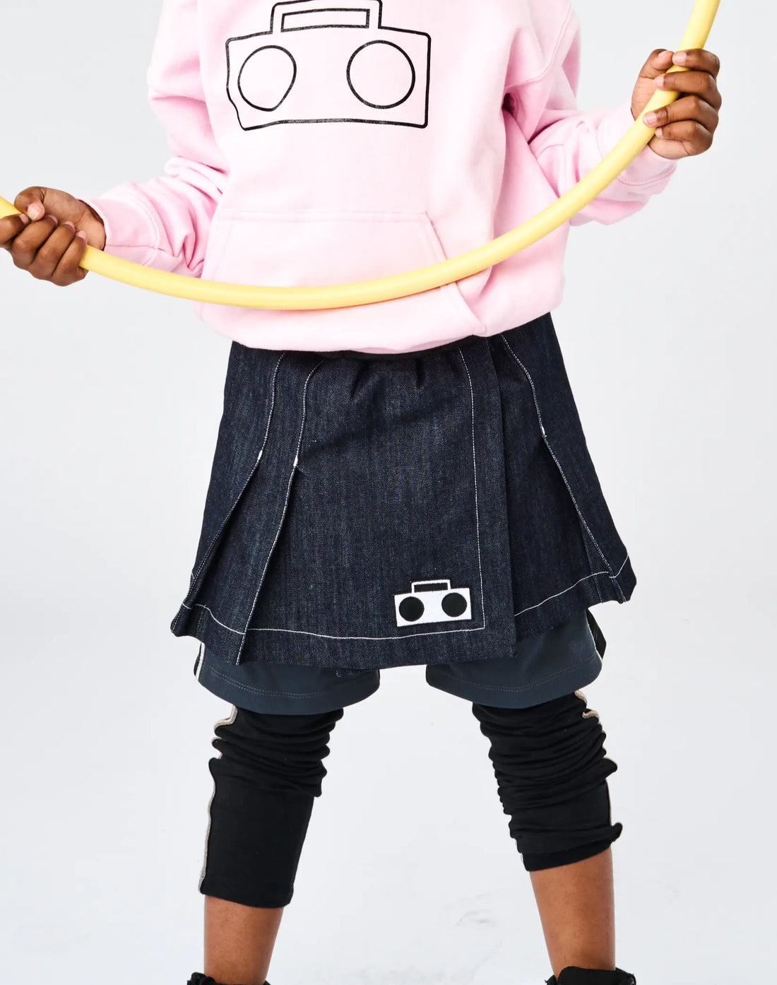 Stereotype Kids Athletic Skort front view showing denim skirt layer, built-in shorts and boombox patch with hula hoop