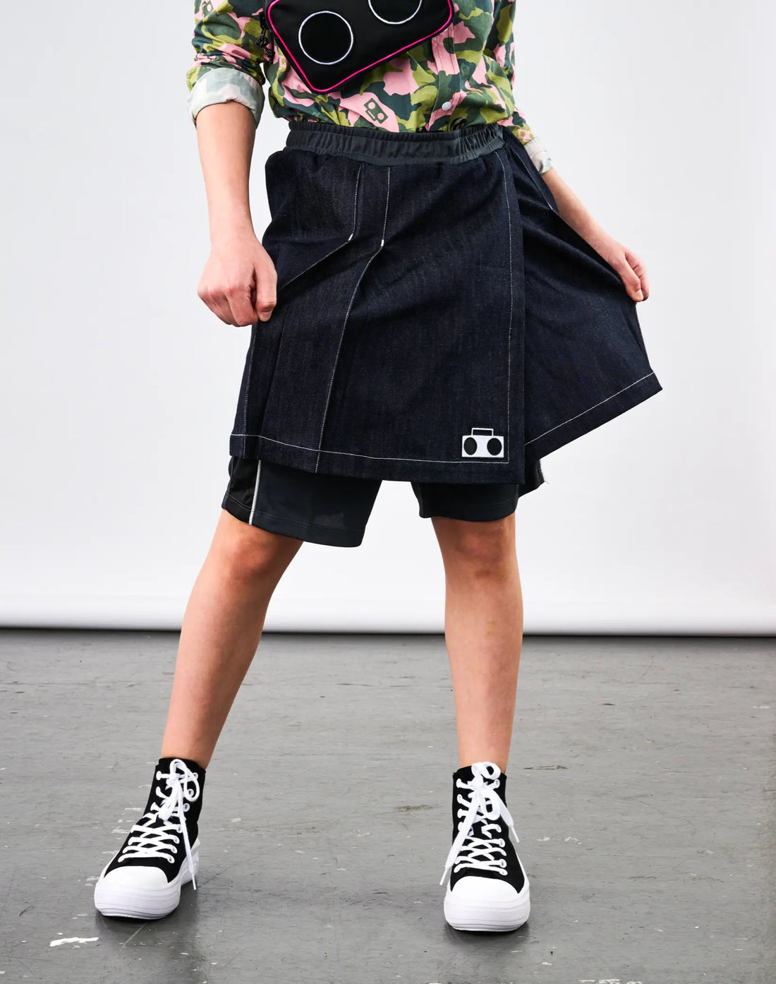 Stereotype Kids Athletic Skort lifting denim layer to show built-in grey mesh athletic shorts underneath