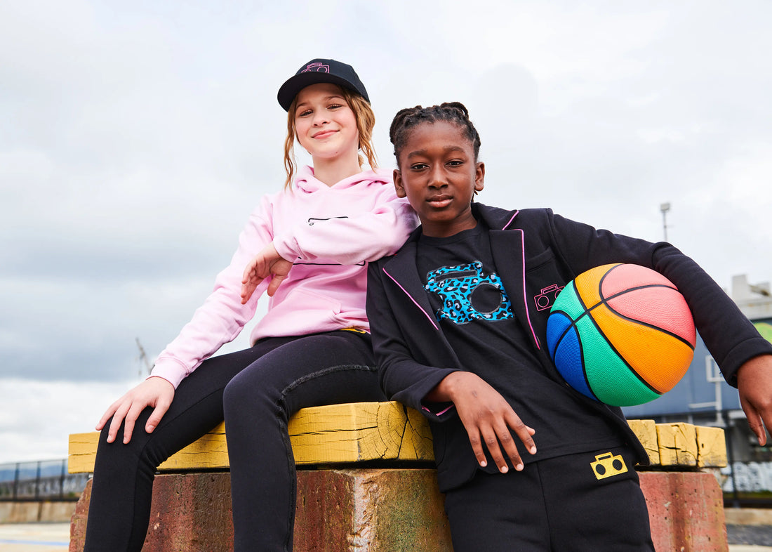 Two kids wearing StereoType Kids pink Boombox Logo Hoodie and Cheetah Boombox Blazer with rainbow basketball in San Francisco