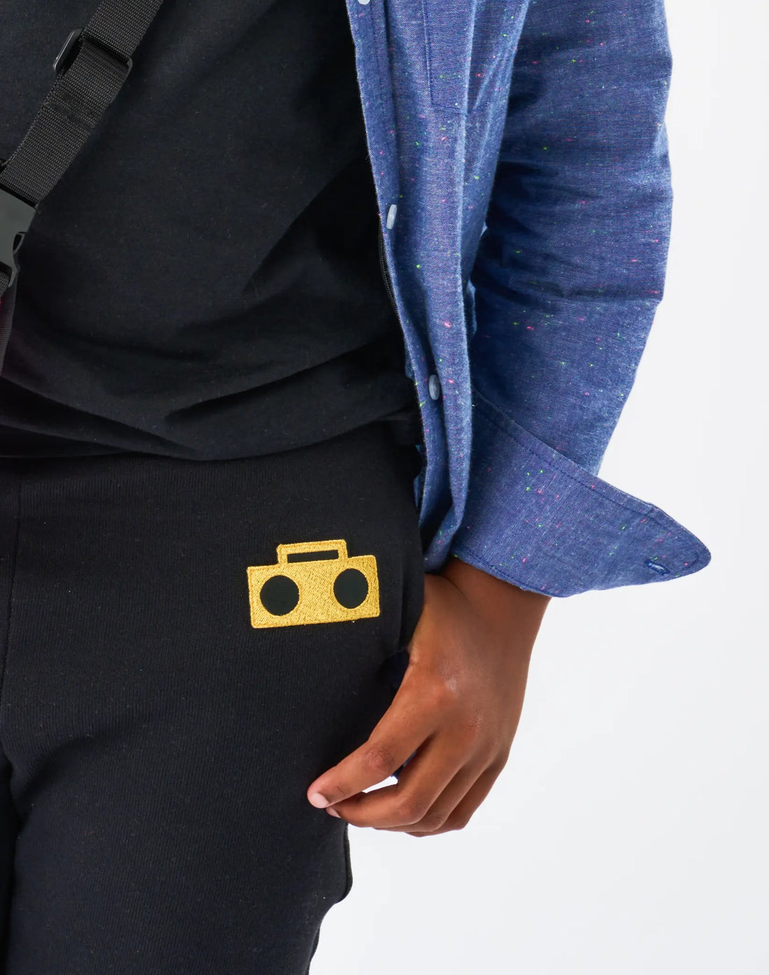 Stereotype Kids Boombox Knit Sweats closeup of gold embroidered boombox logo patch on black fleece with sparkle trim