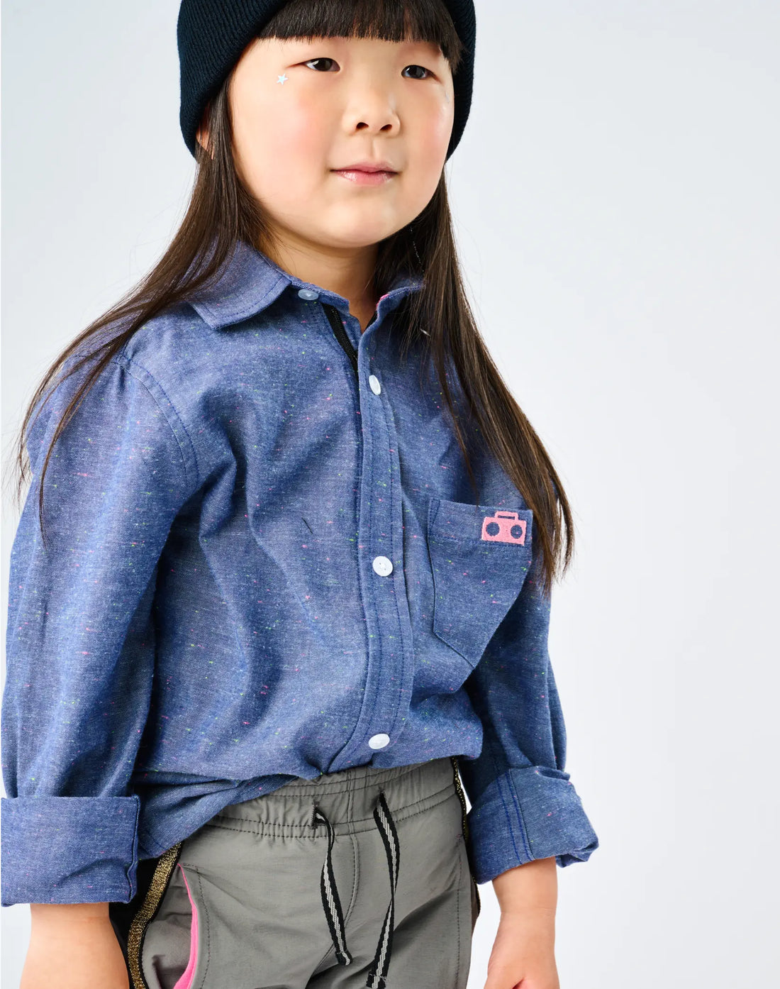 Stereotype Kids Chambray Button-down Zip Shirt showing pink boombox pocket patch and neon rainbow speckle fabric detail