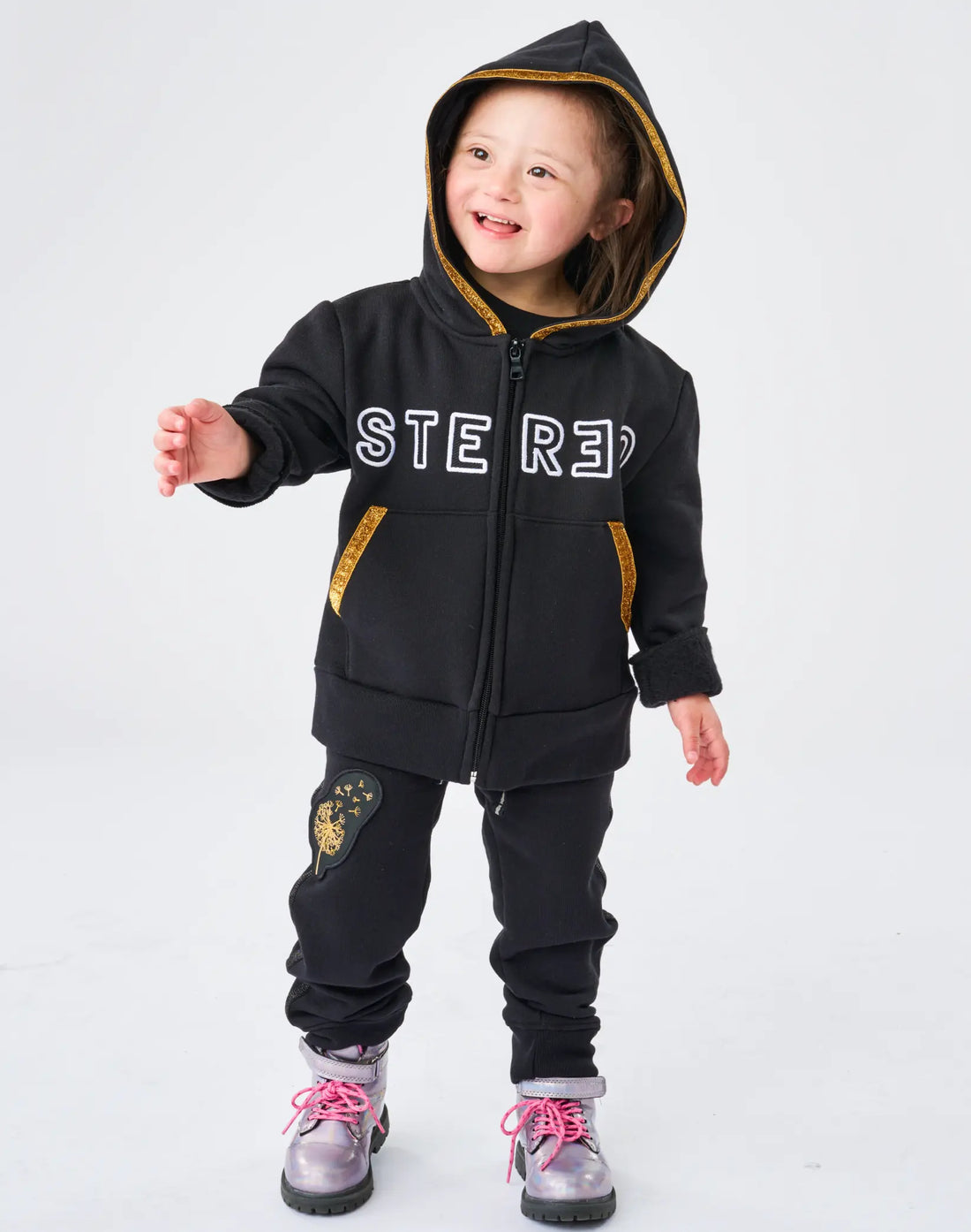 Child wearing a black hoodie and pants with 'STEREO' branding on a white background