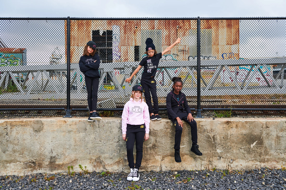 Four kids wearing StereoType Kids gender-inclusive fashion including Boombox Hoodie, Me Is All I Want To Be tee and Boombox kint Sweats in urban San Francisco