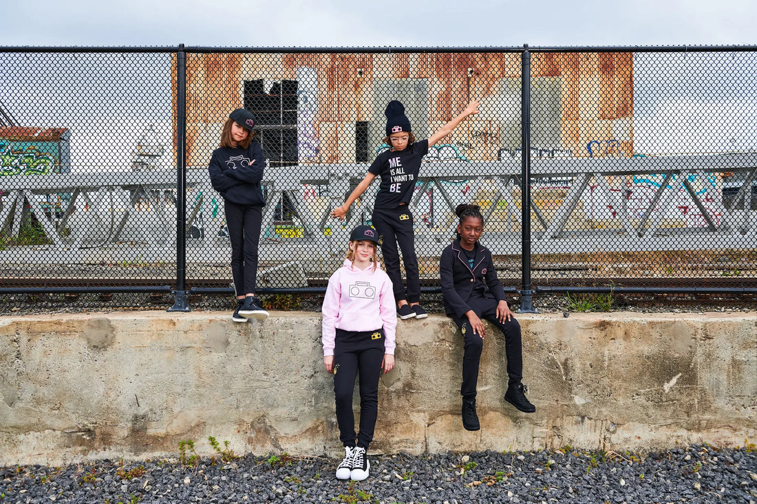 Four kids wearing StereoType Kids gender-inclusive fashion including Boombox Hoodie, Me Is All I Want To Be tee and Boombox kint Sweats in urban San Francisco