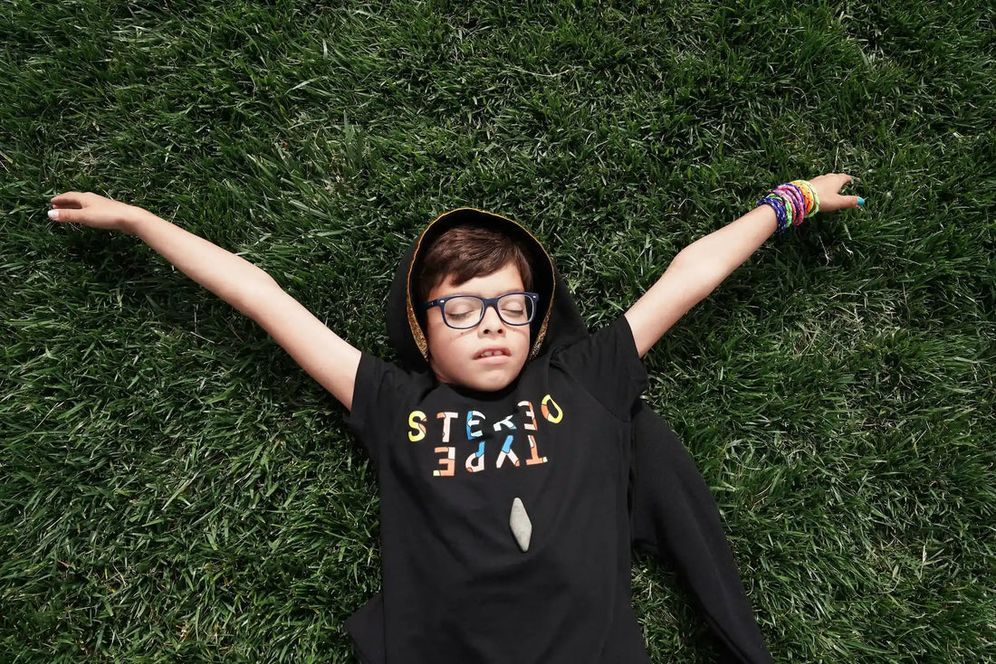 Co-Founder-Jacob lying in grass wearing StereoType Kids Logo graphic tee