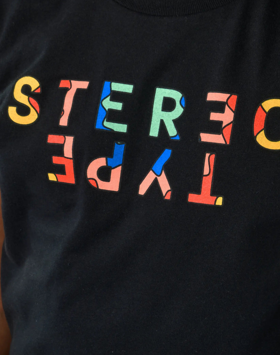 Close-up of StereoType Kids Kaleidoscope Logo tee graphic featuring multicolor mirrored STEREOTYPE wordmark