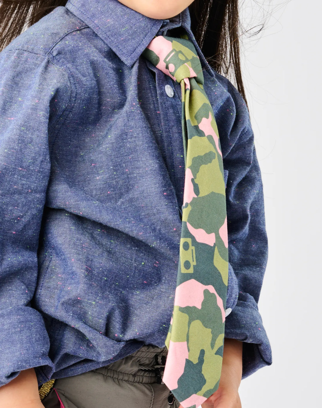 Stereotype Kids Zip Camo Tie closeup showing pink camo boombox print against neon speckle chambray,  zipper closure at collar